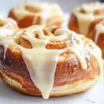 A tray of freshly baked bread flour cinnamon rolls topped with drippy cream cheese icing